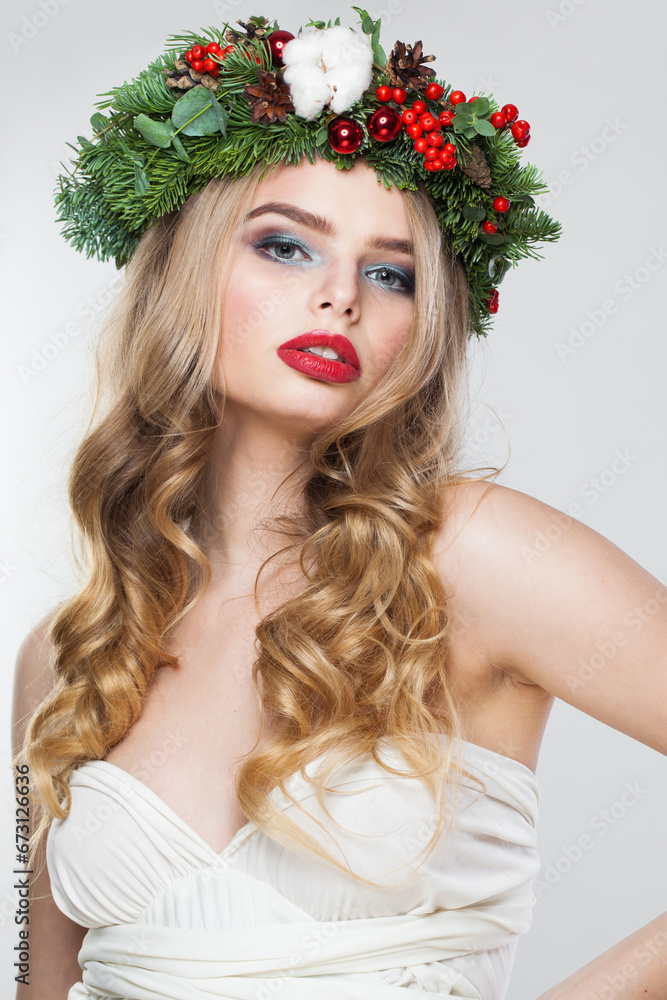 Naklejka premium Elegant blonde woman portrait. Fashion female model with blond curly hairstyle, make-up and green and red winter accessories posing on white background