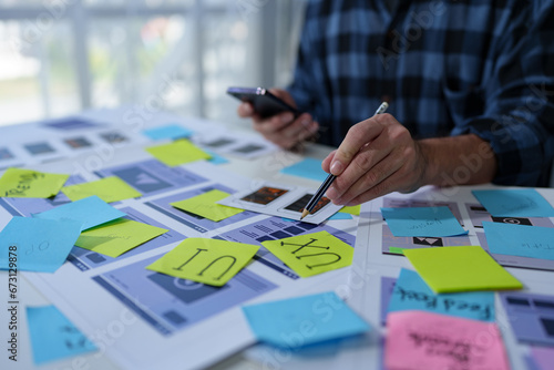 UX developers and UI designers spend more thought planning on mobile app interface design wireframe interface on desk at office creative digital concept. photo