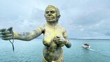  Female giant statue at Samet island port and speedboat in  background.