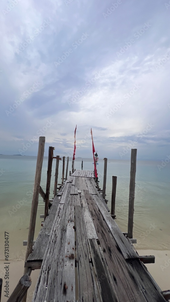 Perspective view of wooden bridge to the clam sea.