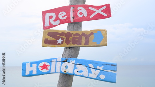 Wooden signpost on the beach, relax stay holiday concept. © Veruree