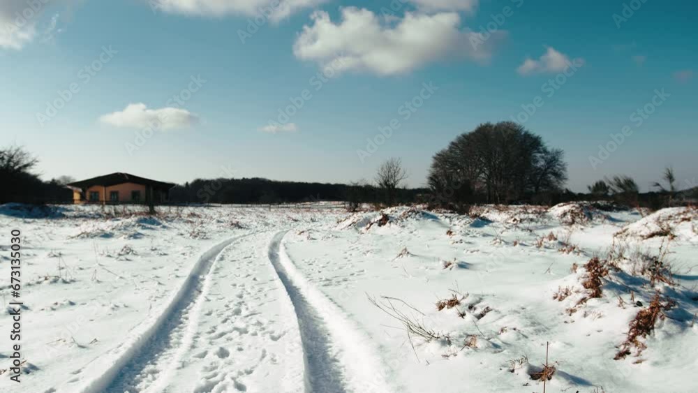 small house surrounded by snow with vehicle traces small house surrounded by snow with vehicle traces