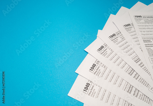 Top view of Forms 1040 U.S. Individual income tax return on a blue background photo