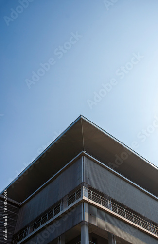 The corner of a modern building with a play on lines and geometry. Minimalist and modern architectural style.