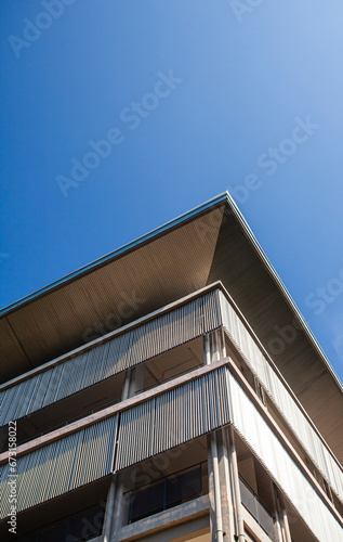 The corner of a modern building with a play on lines and geometry. Minimalist and modern architectural style.