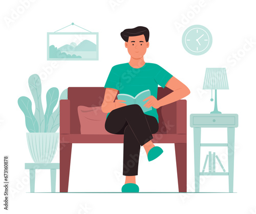 Man Sitting on Sofa and Reading a Book