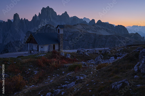 Dolomites. Evening landscape of the Italian Alps after sunset. The Cappella degli Alpini chapel in the foreground. In the background, the Cadini di Misurina mountain range photo