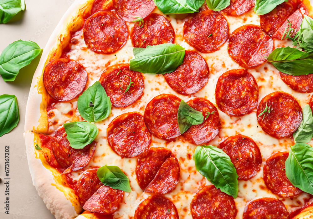 Pepperoni pizza garnished with basil leaves Pepperoni pizza garnished with basil leaves