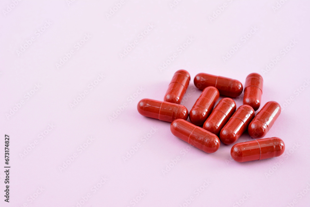 heap of red capsules on the pink background copy space heap of red capsules on the pink background copy space