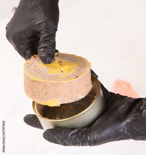 piece of beef pork liver pate on the white background with peppers woman in the black gloves takes out