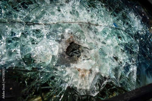 Bullet hole in armor-piercing glass. Armor piercing glass of damaged military infantry fighting vehicle during war between russia and Ukraine. Background, texture bulletproof glass after an attack