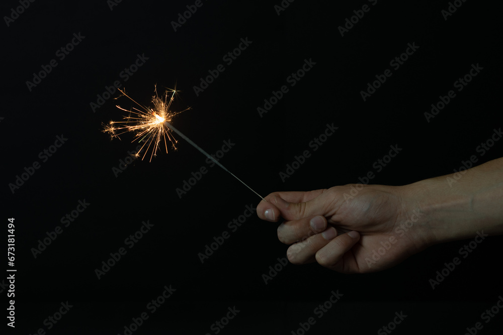Fototapeta premium Una mano sujetando una bengala encendida