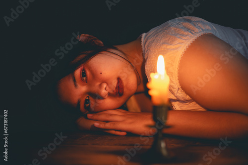 Candle light with young girl praying in dark night background. Woman person worship God with faith and belief. religion, christian prayer concept. Christian teenage girl and faith.