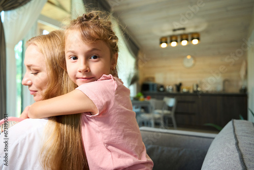 Pretty daughter hugging her attractive mother by shoulders © Viacheslav Yakobchuk