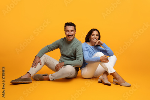 Glad calm happy senior european husband and wife in casual sit on floor, enjoy free time
