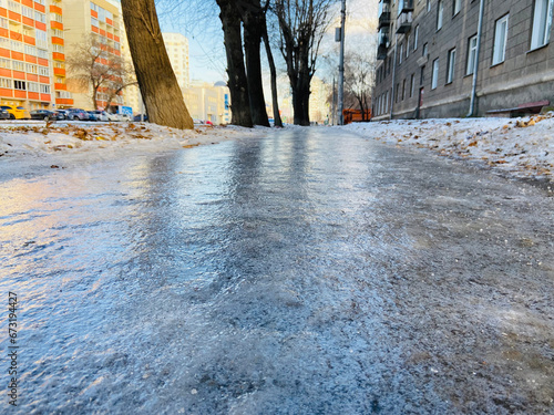 The sidewalk is covered with ice