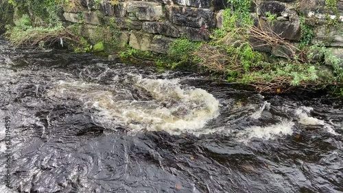 River water running past a stone bank.