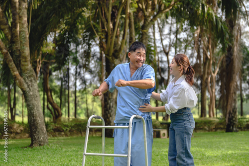 Daughter takes care of father and encourages him during his illness at hospital garden. The happiness of old adult patients while rehabilitation or physical therapy of retired patients.