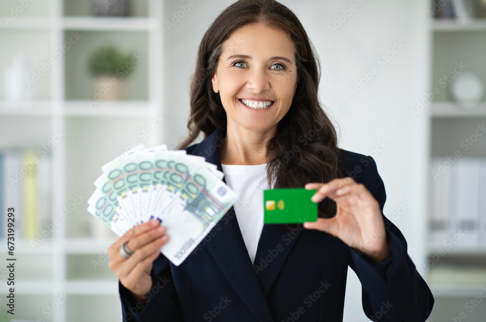 Businesswoman recommends credit card, holds a lot of money cash Businesswoman recommends credit card, holds a lot of money cash
