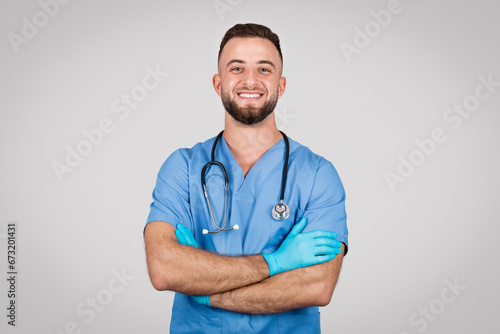 Confident european doctor man with crossed arms and smiling at camera