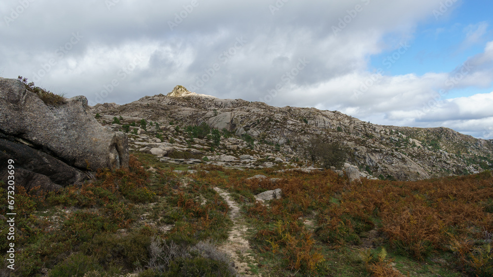 Path through mountain landscape of granite rocks with green vegetation, Peneda-Geres National Park, Vilar da Veiga, Portugal Path through mountain landscape of granite rocks with green vegetation, Peneda-Geres National Park, Vilar da Veiga, Portugal