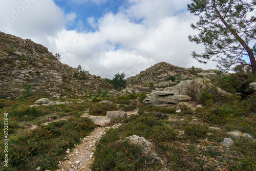 Path through mountain landscape of granite rocks with green vegetation, Peneda-Geres National Park, Vilar da Veiga, Portugal