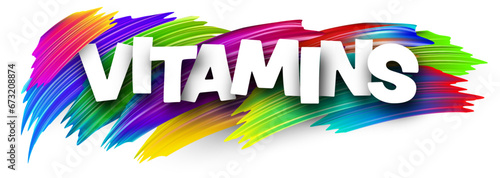 Vitamins paper word sign with colorful spectrum paint brush strokes over white.