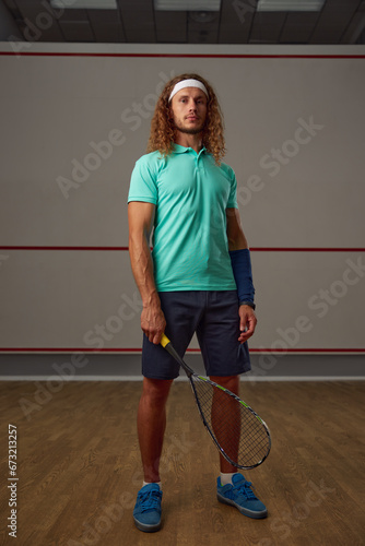 Portrait of confident male squash player standing with racket ready for game © Nomad_Soul