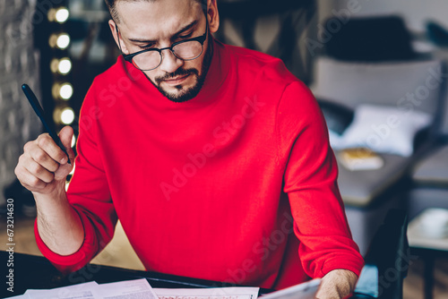pensive male graphic designer looking at blank sketch and feeling puzzled on new ideas