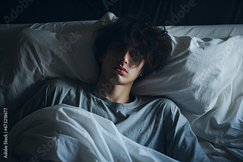Young man lying on bed feeling depressed and with anxiety