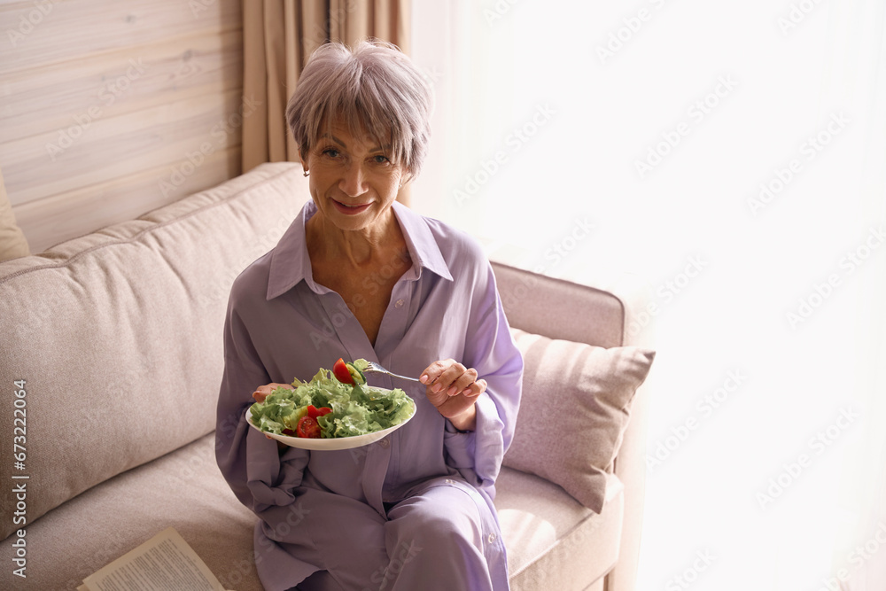 Cute old lady sitting comfortably on a cozy sofa