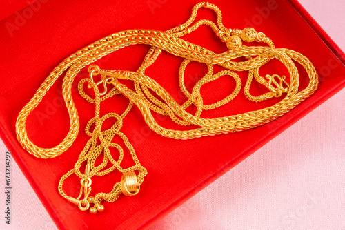 Group of gold necklaces in red velvet box.