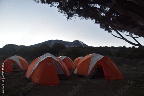 Camping in an orange tent on the Lemosho route while trekking Mount Kilimanjaro in Tanzania