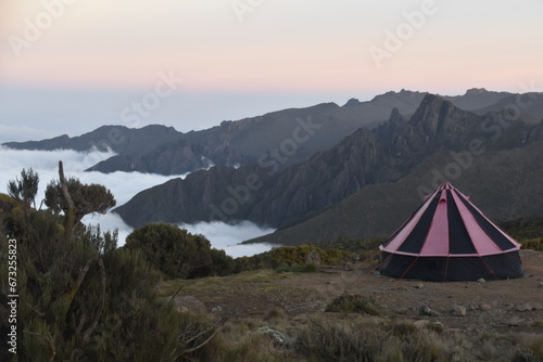 Camping in an orange tent on the Lemosho route while trekking Mount Kilimanjaro in Tanzania