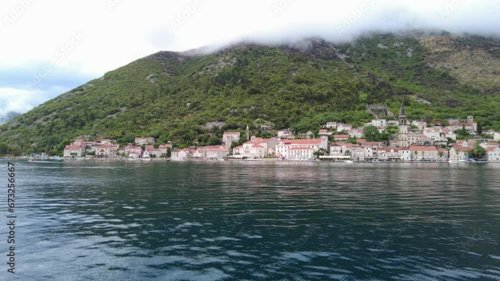 A scenic view of the town of Perast and surrounding mountains from the Bay of Kotor, Montenegro A scenic view of the town of Perast and surrounding mountains from the Bay of Kotor, Montenegro