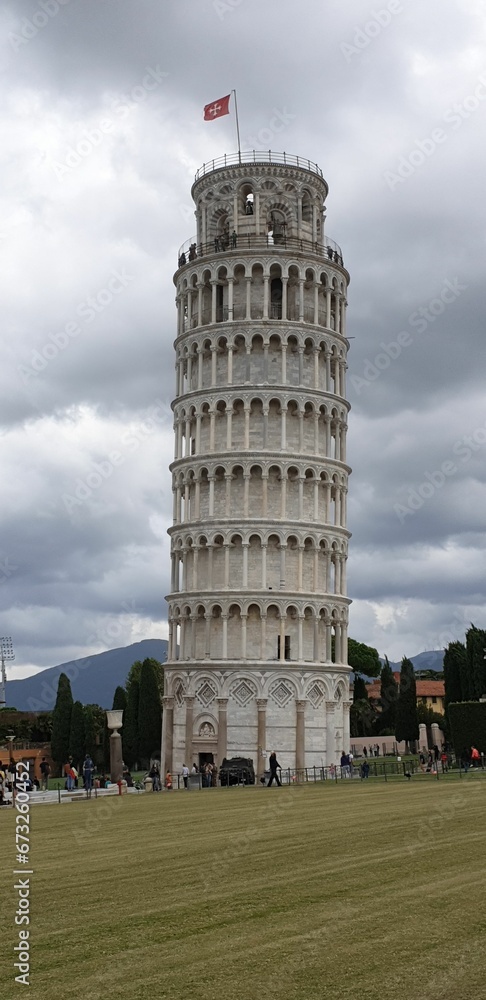 Leaning tower of Pisa with people walking around it in Italy