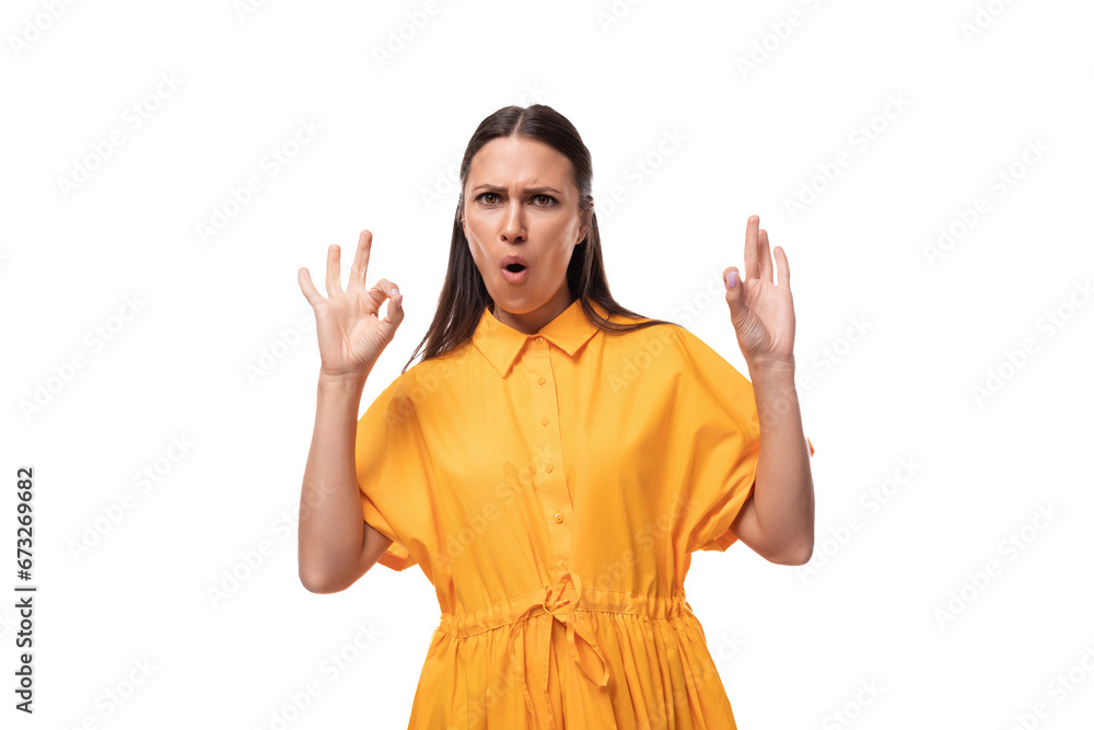 black-haired slender woman dressed in an orange dress is confident on a white background black-haired slender woman dressed in an orange dress is confident on a white background