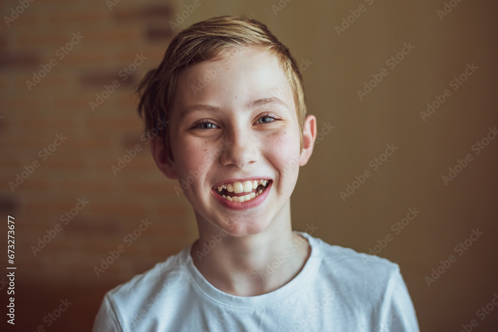 Headshot of happy boy smiling looking at camera posing with wearing casual clothes over gray background. Front View Shot Headshot of happy boy smiling looking at camera posing with wearing casual clothes over gray background. Front View Shot
