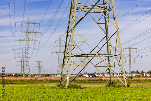 Large steel construction in the foreground and many electricity pylons in the background photo