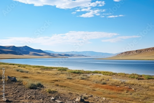 Steppe Lake. Beautiful landscape of a lake in the steppe against the backdrop of hills and a beautiful blue sky with clouds.