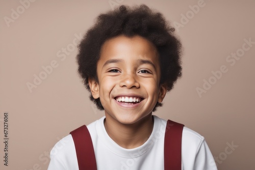 portrait of an attractive african american boy smiling against a grey background portrait of an attractive african american boy smiling against a grey background african - american little kid with cur © Shubham