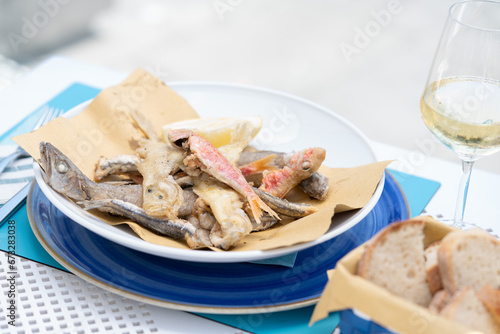 Fried seafood, called "frittura di pananza", typical Mediterranean fish cooked fried and accompanied by a glass of cold white wine