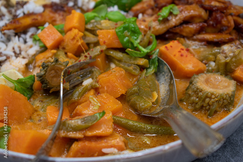 Thai vegan red curry made with seitan (plant based meat) sweet potatom rice, Along with rice and starch pancakes photo