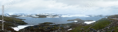 Dense fog and summer mountain landscape with lake and snow (Norway, not far Nigardsbreen glacier). Panorama.