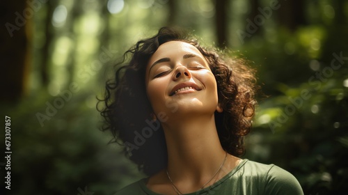 Side of a portrait of a relaxed woman, eyes closed, breathing fresh air in a green forest, copy space