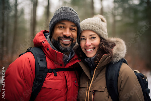 Middle age mixed race couple enjoying outdoors activity in winter woods