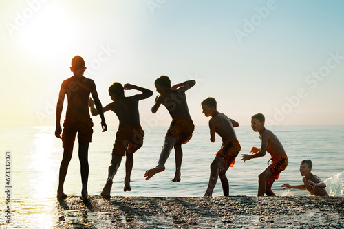 Sequence of jump. Moments of schoolboy jumping from stone pier into sea at sunrise doing tricks in combined image sequence