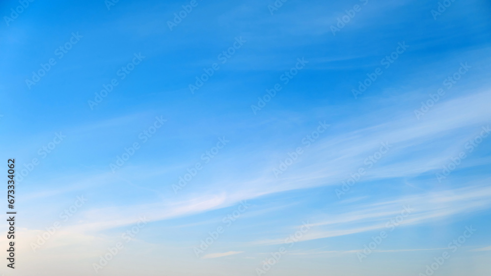 White cirrus and stratus clouds in a blue daytime sky - obrazy, fototapety, plakaty 