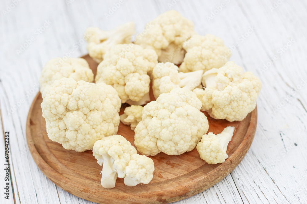Cauliflower vegetables standing on a white wooden table Cauliflower vegetables standing on a white wooden table