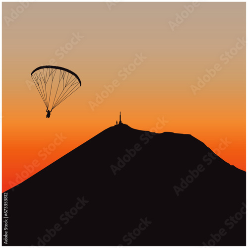 Puy de dome volcano; paraglider silhouette at sunset